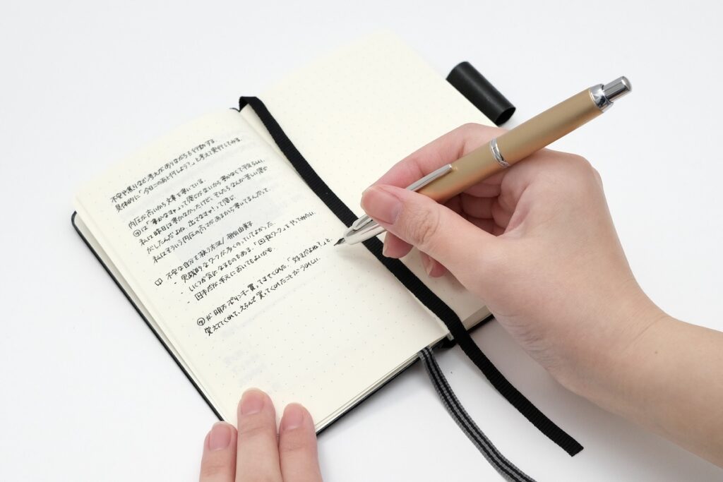 手帳に万年筆で書き込む様子