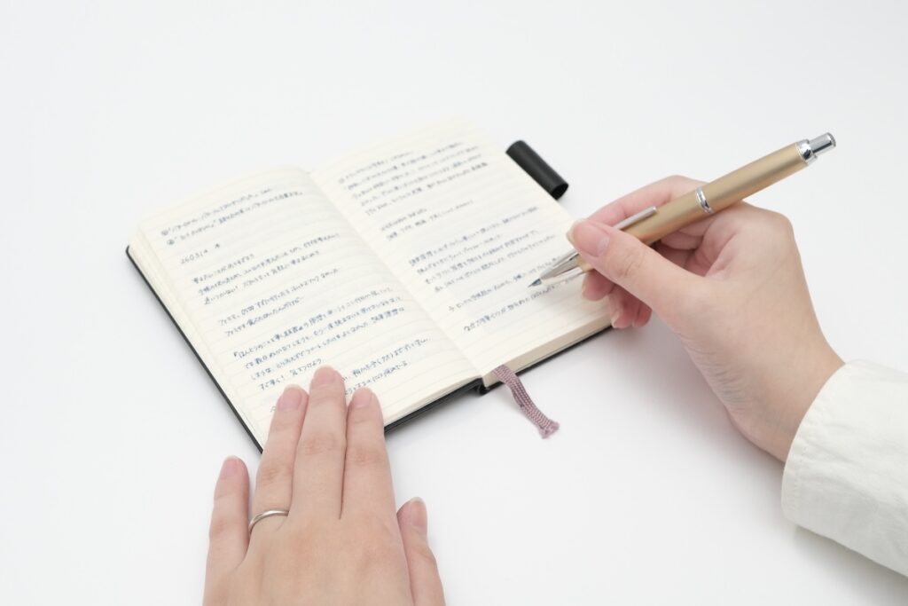 ノートに万年筆で書き込む様子