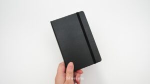 手にノートを持っている様子